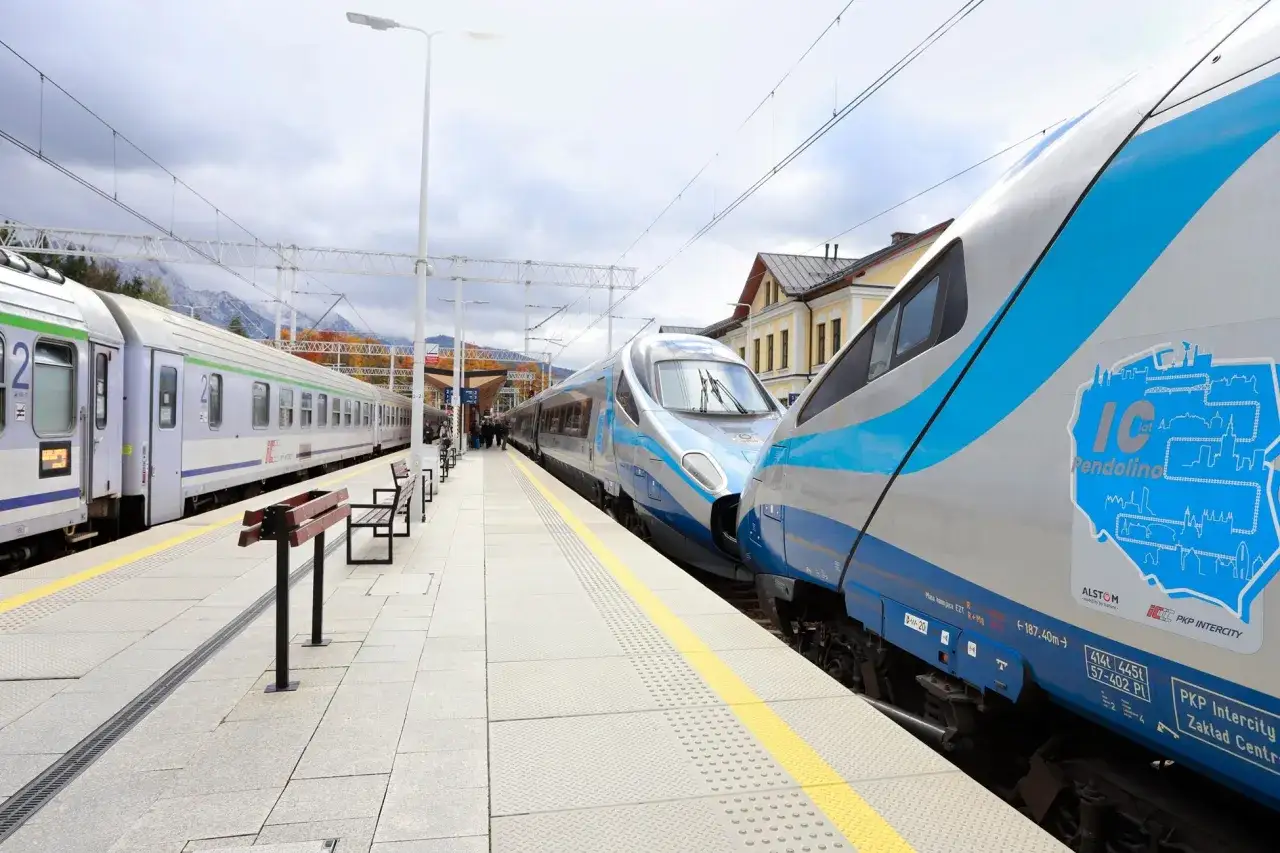 Dwa nowoczesne pociągi PKP Intercity Pendolino stoją na peronie. Jeden z nich ma niebiesko-srebrne malowanie.