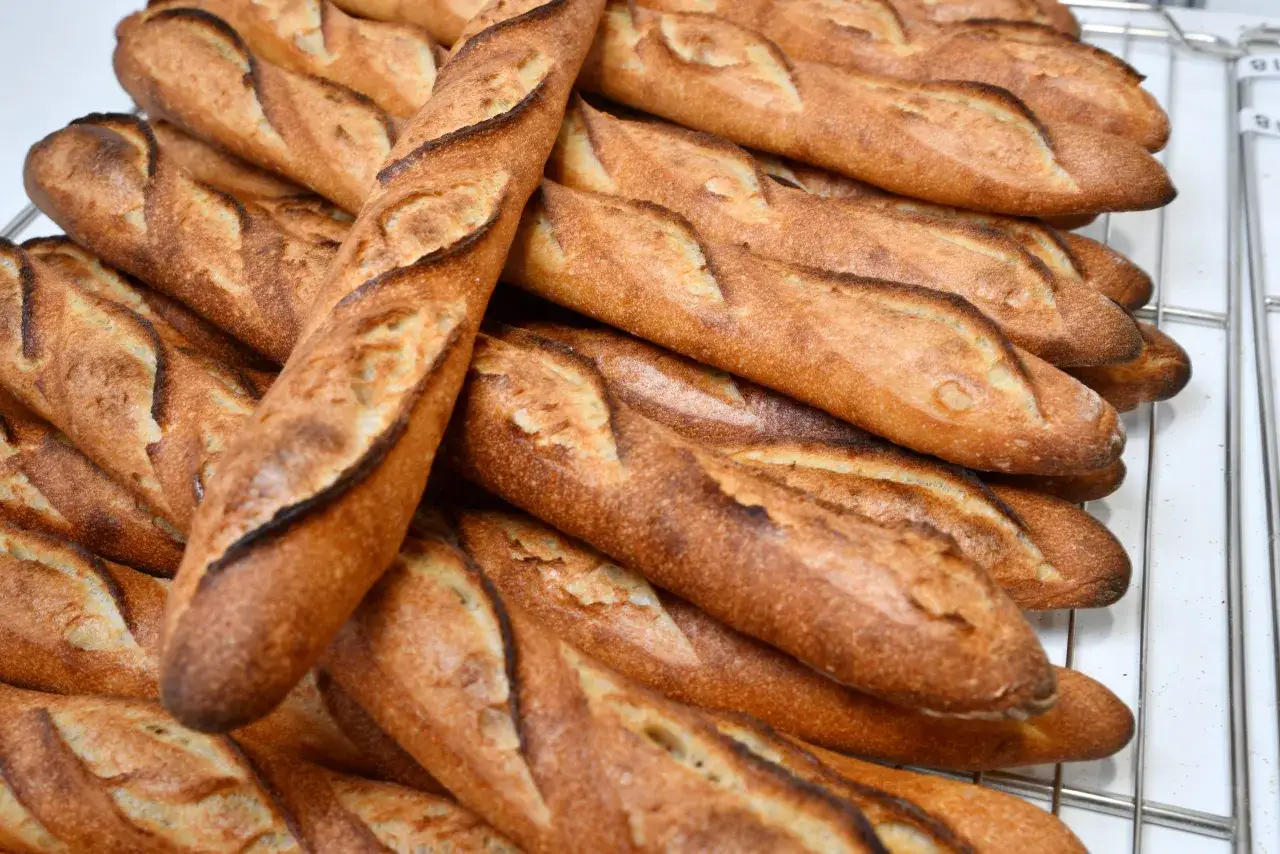 Baguettes traditionnelles dorées, parfaites pour une recette CAP boulangerie. Croustillantes à l'extérieur, moelleuses à l'intérieur.