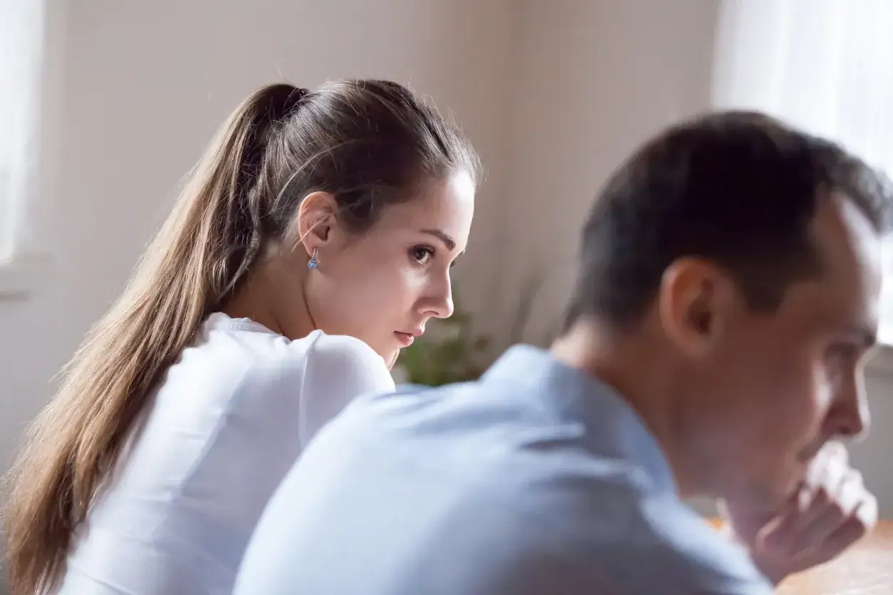Una donna guarda con tristezza un uomo, il suo sguardo dice: ho perdonato un tradimento ma non riesco a dimenticare.