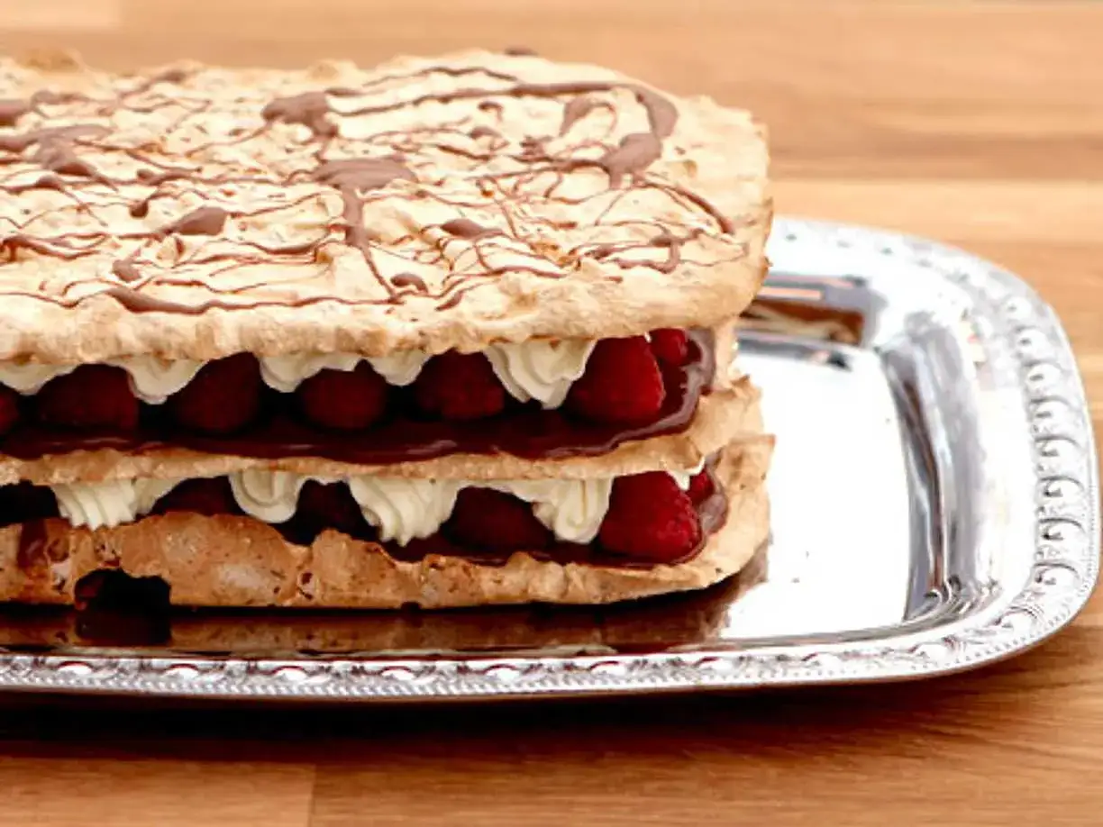 En härlig rice krispies tårta med lager av grädde, choklad och färska hallon, toppad med chokladdrizzle.