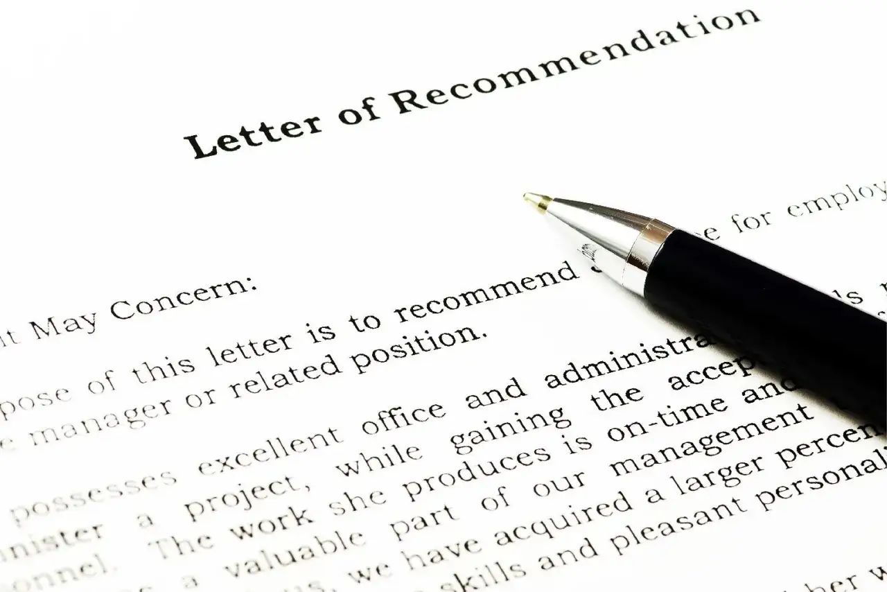 Une lettre de recommandation est prête à être signée. Un stylo argenté repose sur le document.
