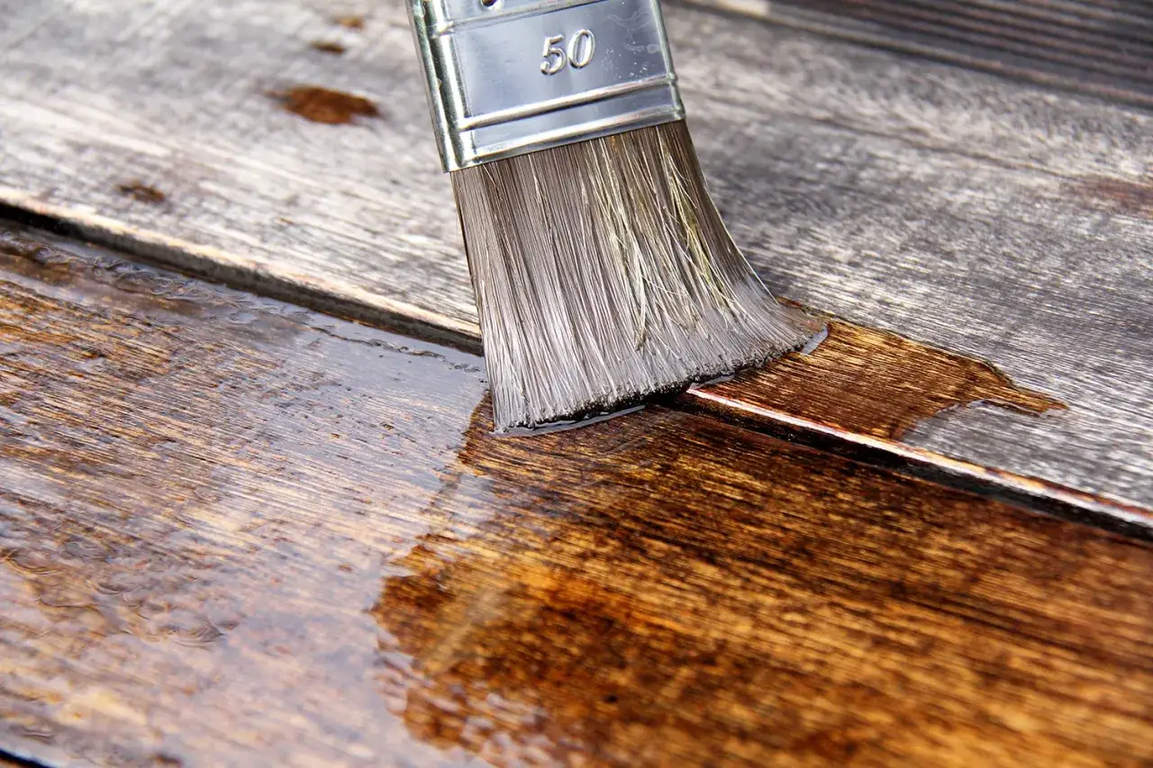 Pennello applica liquido su legno. Un metodo per eliminare tarli legno alcool, proteggendo le fibre.