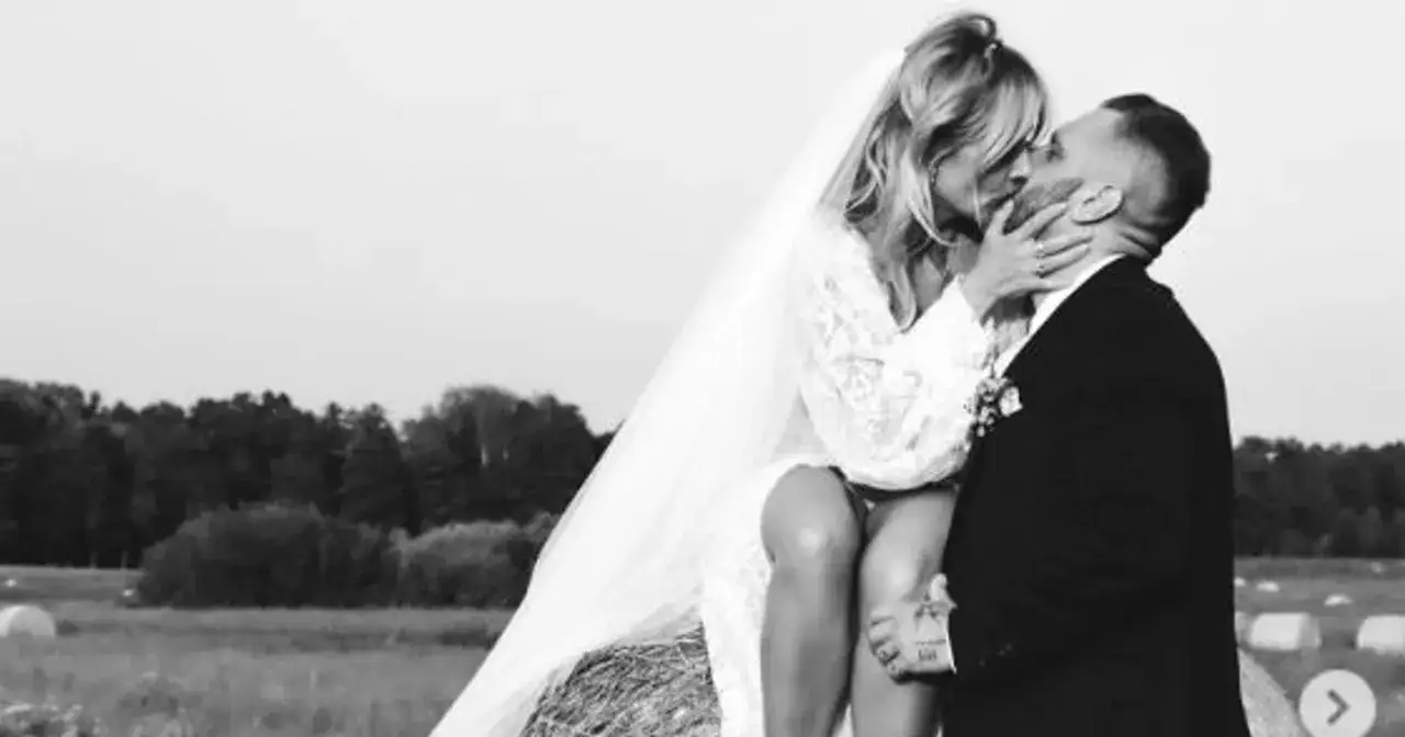 Patrycja Markowska i jej mąż w czułym uścisku na tle pól.
