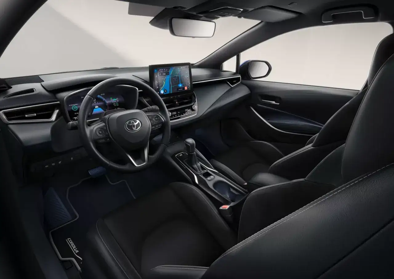 Wnętrze Toyota Corolla 2025: nowoczesny kokpit z ekranem nawigacji, cyfrowymi zegarami i wygodnymi fotelami.