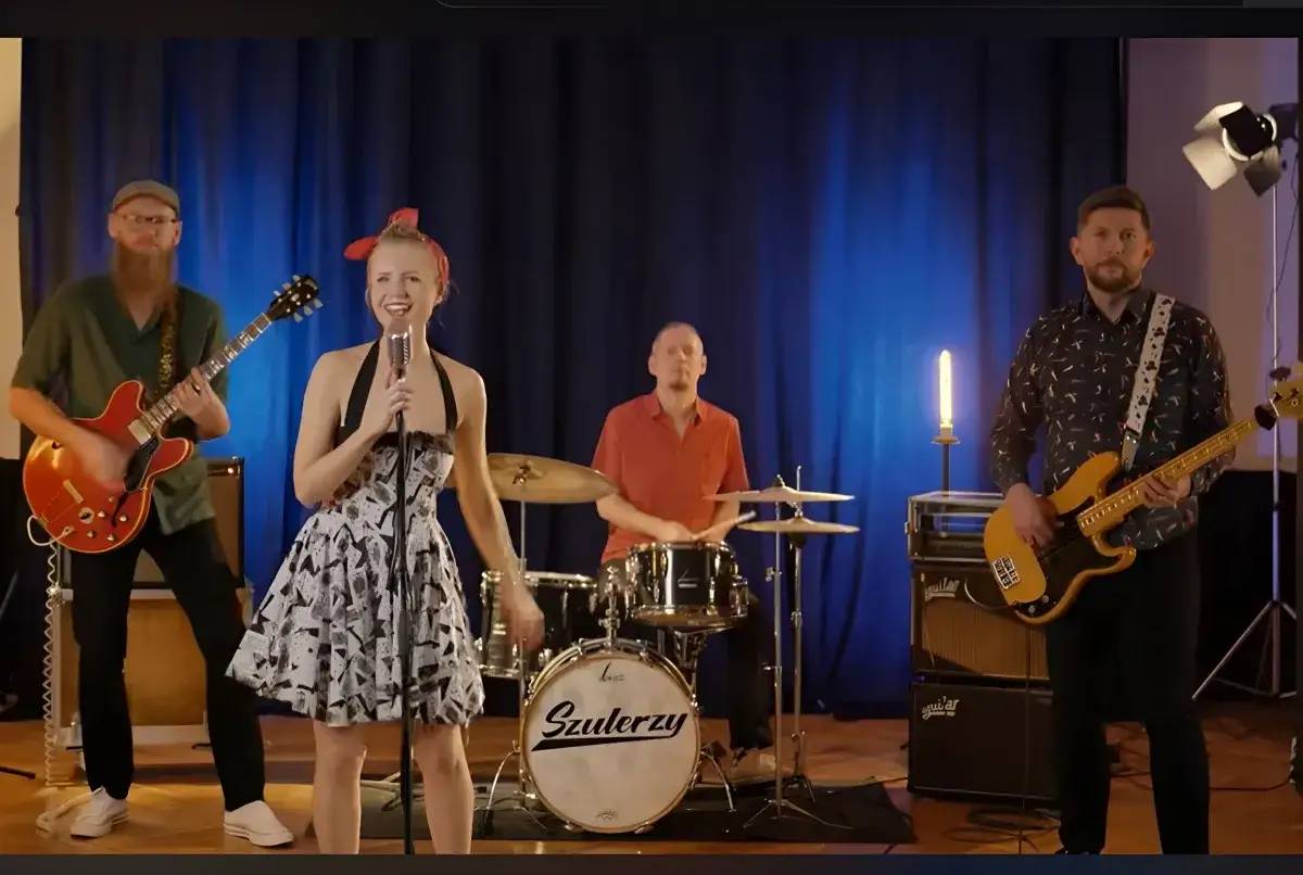 Zespół grający blues. Wokalistka w sukience, gitarzysta, basista i perkusista.