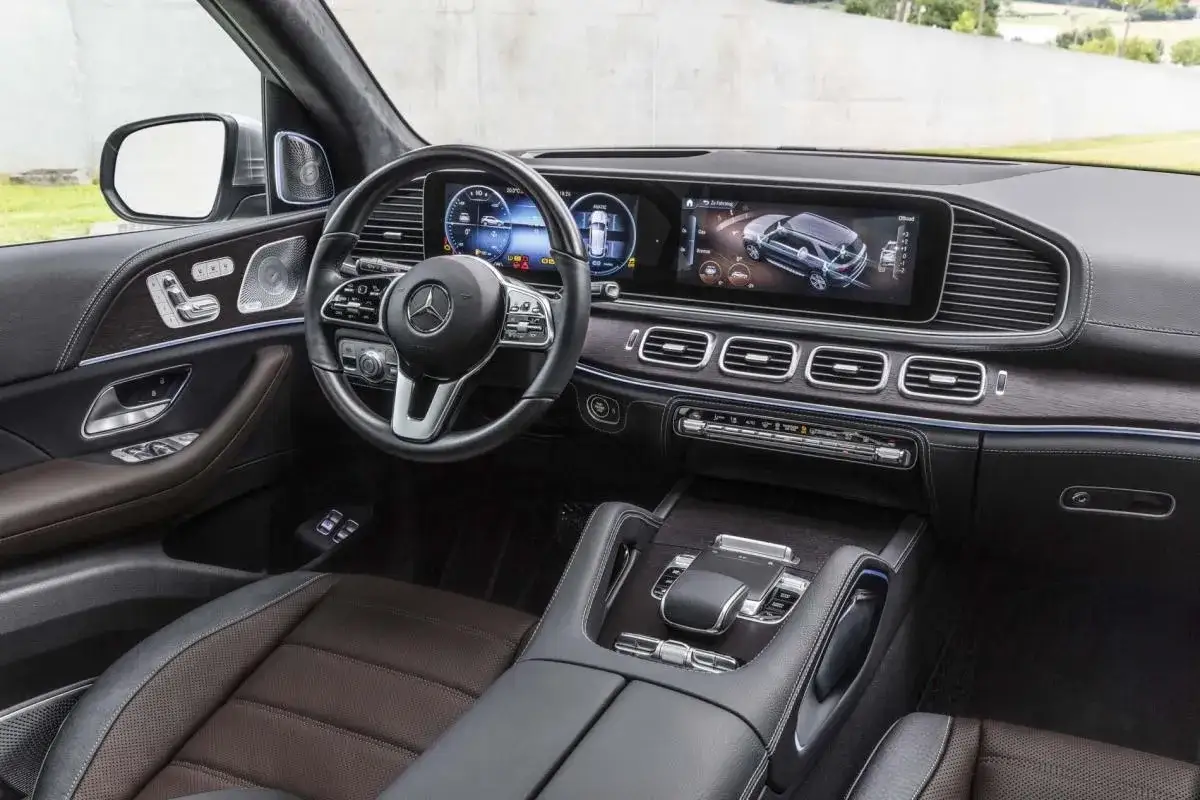 Wnętrze luksusowego **Mercedes GLE 2025** z nowoczesnym kokpitem, dużymi ekranami i eleganckimi detalami.