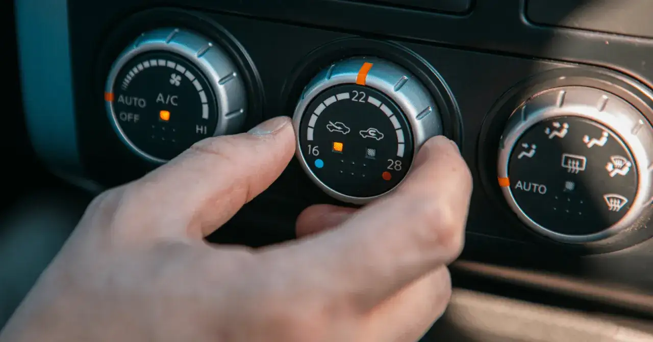 En hand justerar temperaturreglaget f&ouml;r ac i bilen.