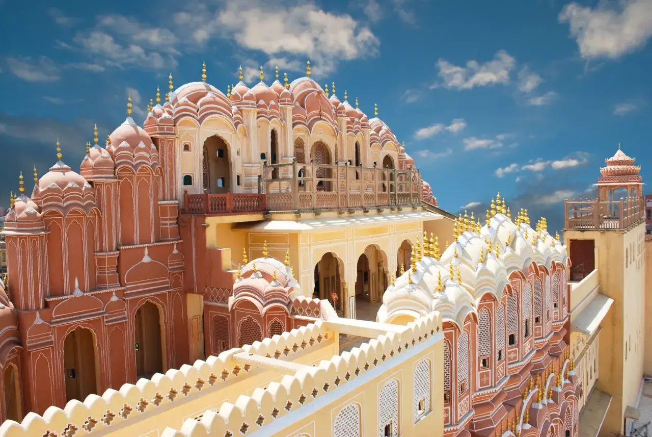 Der Palast der Winde in Jaipur, Indien, mit seinen zahlreichen Fenstern und Kuppeln, die sich gegen einen blauen Himmel abheben.