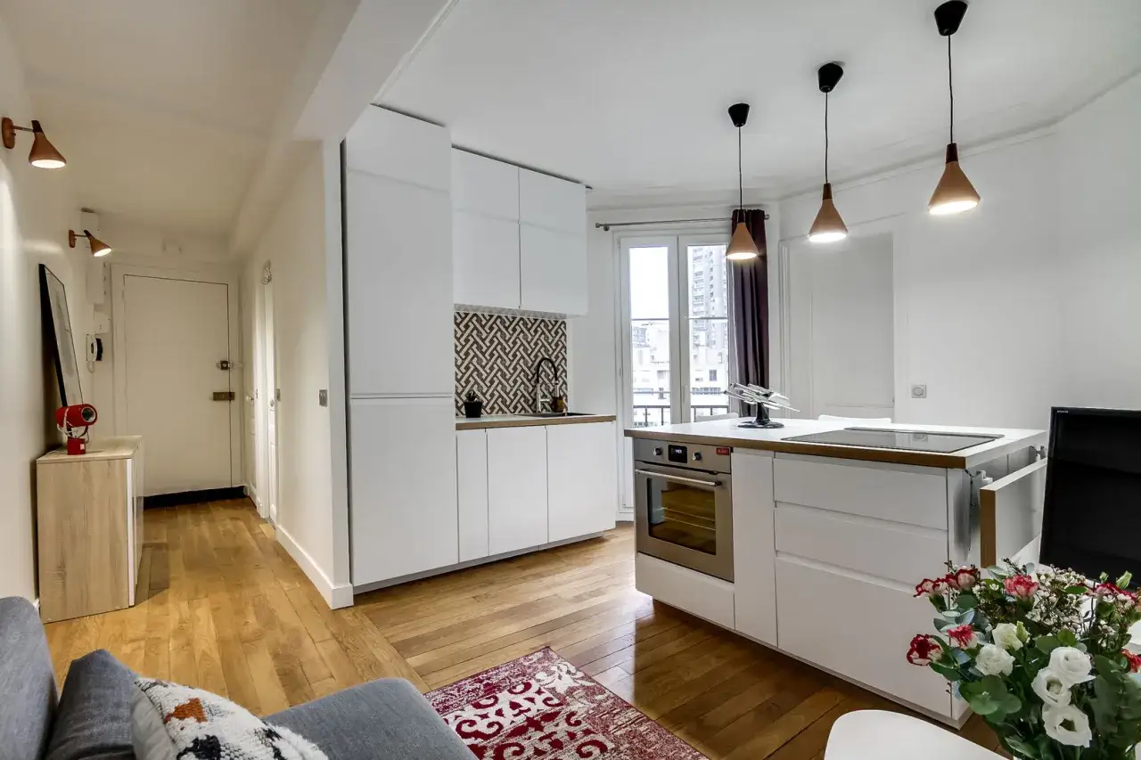 Moderne 50 qm Wohnung einrichten: Offene Küche mit Kochinsel, Holzboden und schmalem Flur.