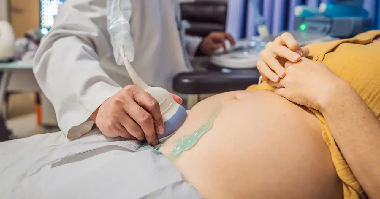 Lekarz wykonuje badanie USG brzucha kobiety, które może być częścią procedury terminacji ciąży.