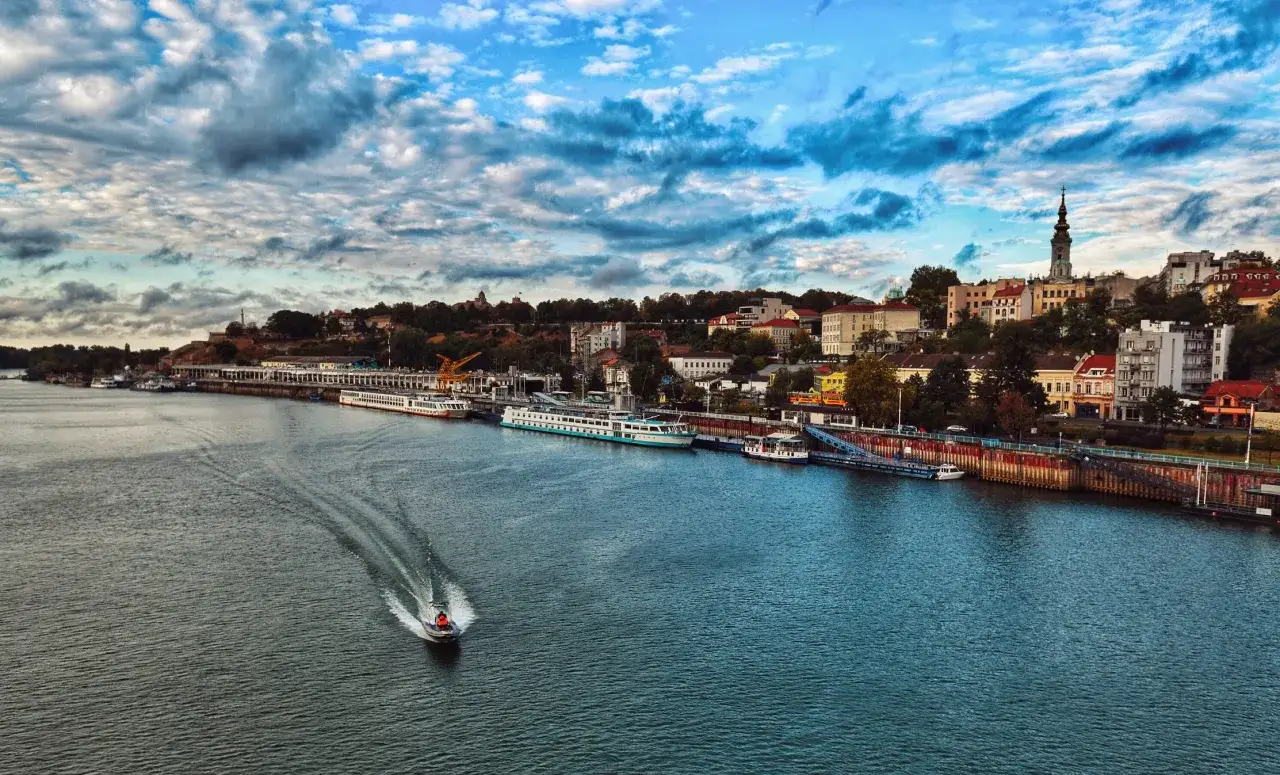 Widok na Dunaj i Belgrad, niegdyś stolicę Jugosławii, z łodzią na wodzie i statkami przy nabrzeżu.
