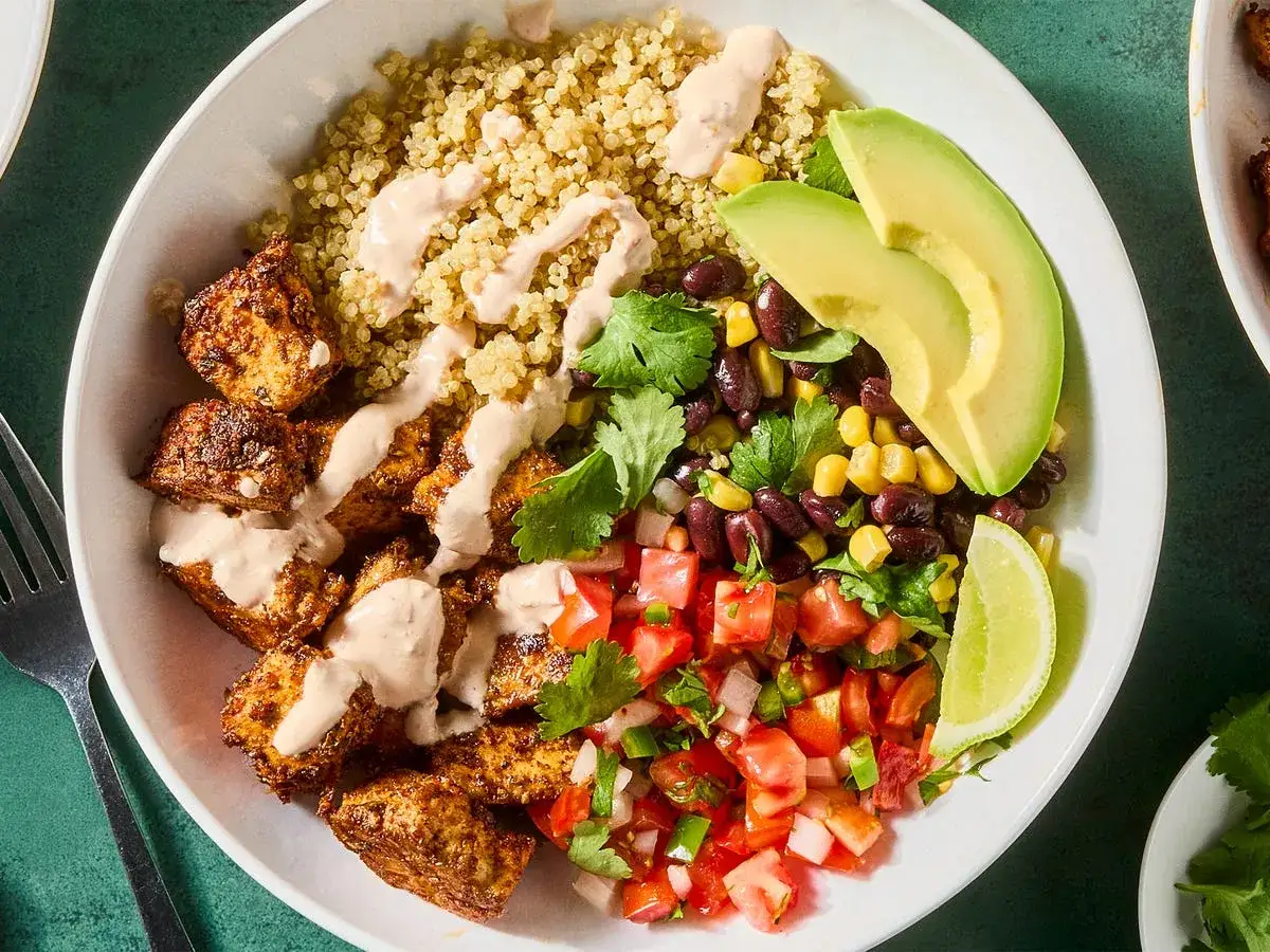 Bunter Quinoa-Bowl mit gew&uuml;rztem Tofu, schwarzen Bohnen, Mais, Avocado, Salsa und Limette. Perfekt f&uuml;r vegetarische High Protein Rezepte.