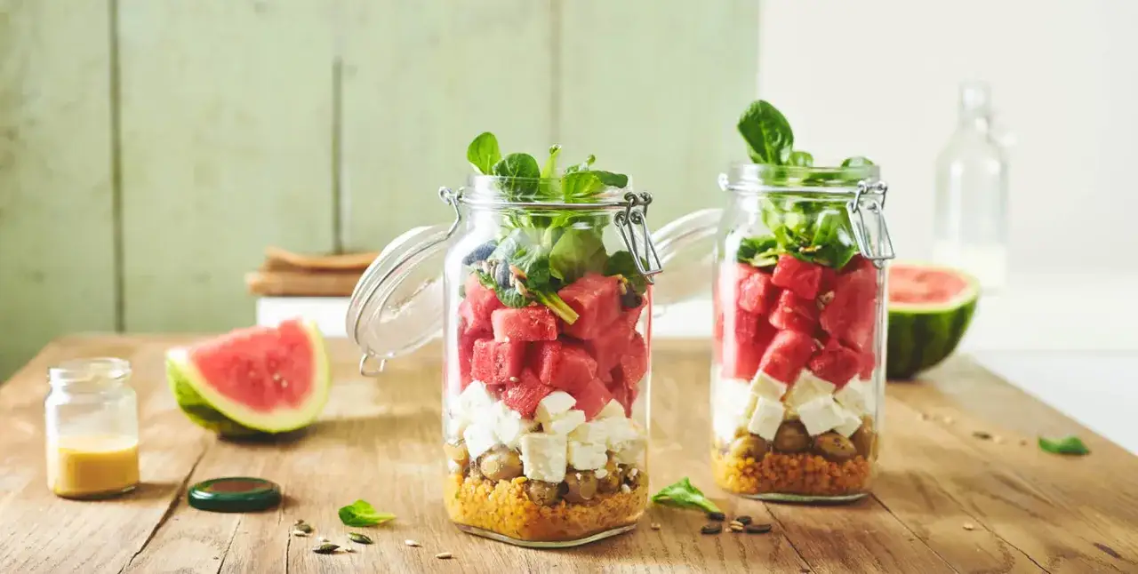 Erfrischender Wassermelonen-Feta-Salat im Glas mit Quinoa und Oliven. Perfekt für unterwegs!