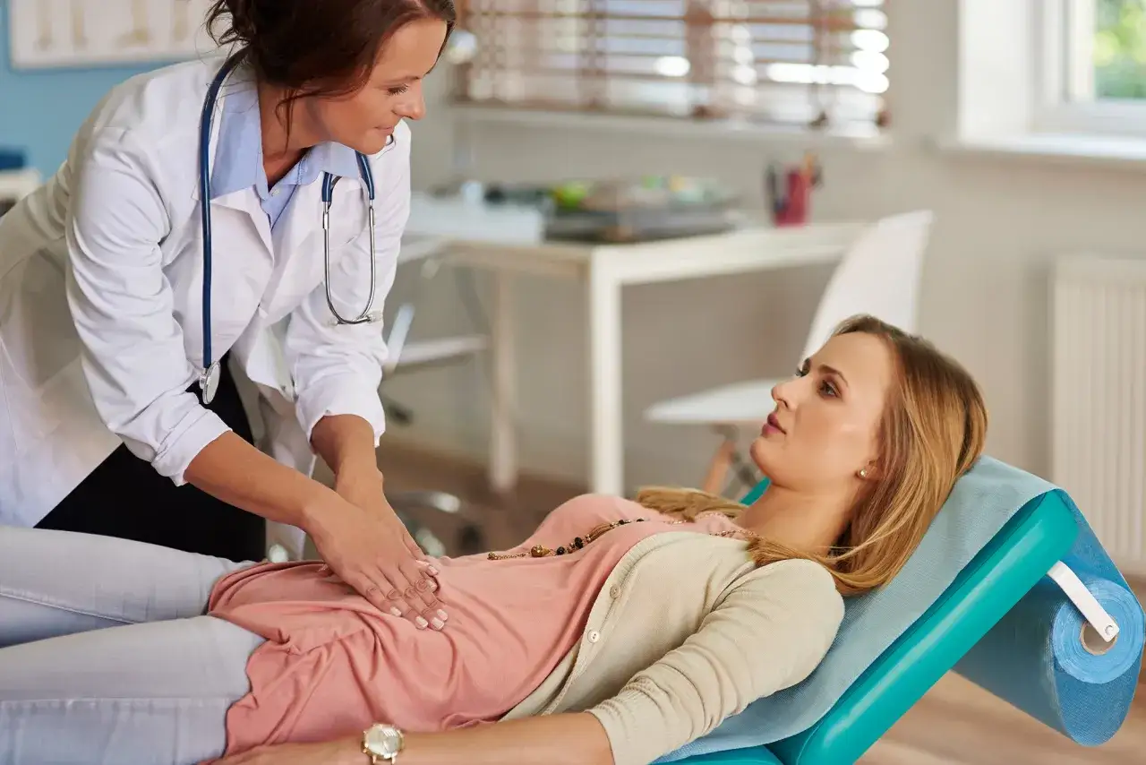 Lekarka bada pacjentkę leżącą na kozetce. Przygotowanie do gastroskopii ze znieczuleniem.