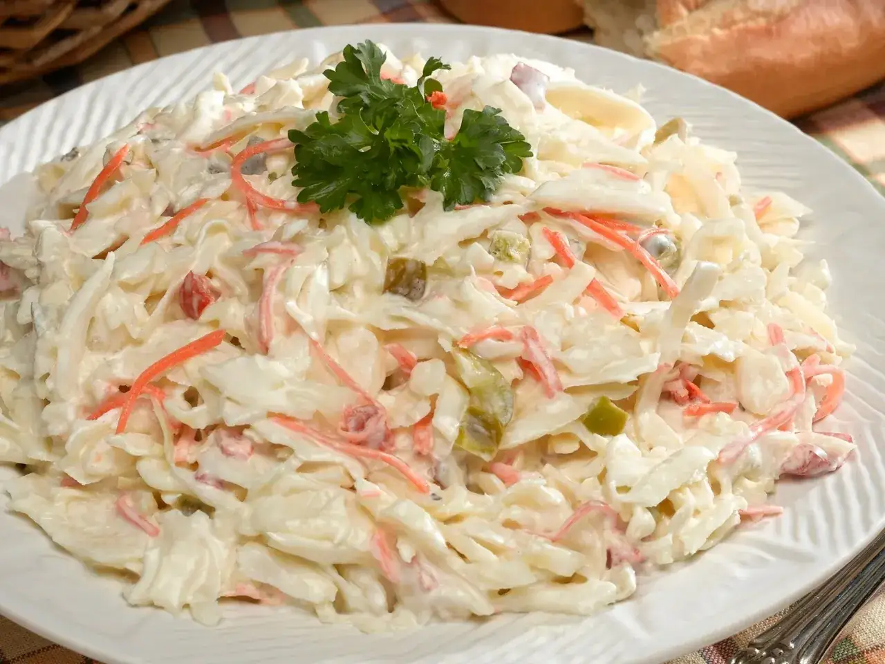 Klasyczny coleslaw z marchewką i zielonymi ogórkami, polany kremowym sosem. Idealny dodatek do obiadu.