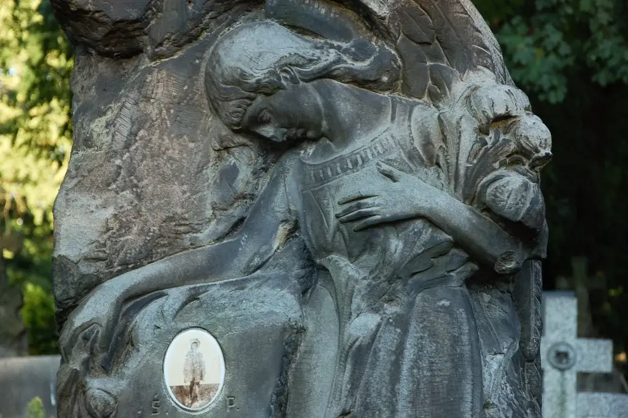 Anioł opłakuje zmarłego, którego portret znajduje się na nagrobku. Odkryj najciekawsze symbole na starych nagrobkach i ich ukryte znaczenie.
