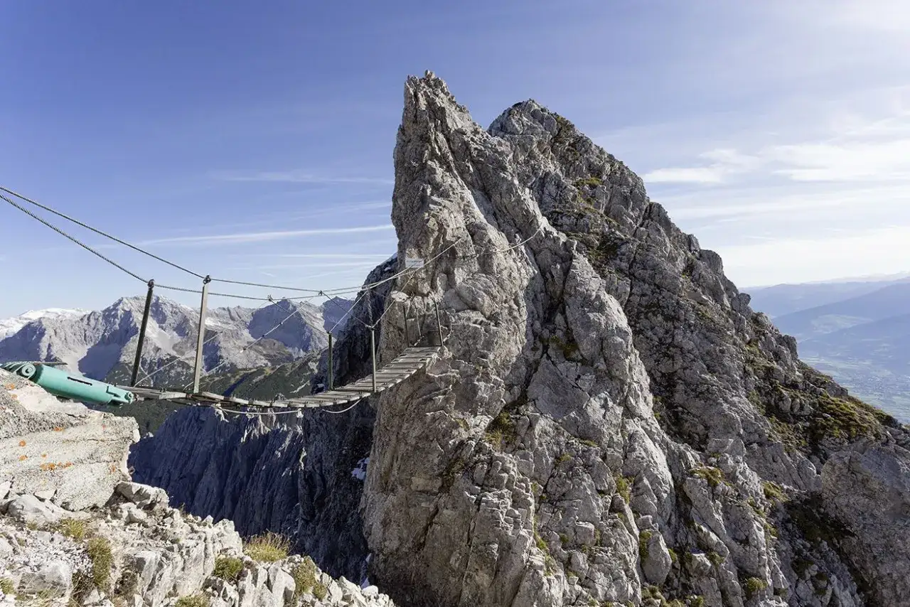 Most przygody na via ferrata w Austrii, zawieszony nad przepaścią, łączy skalne szczyty.