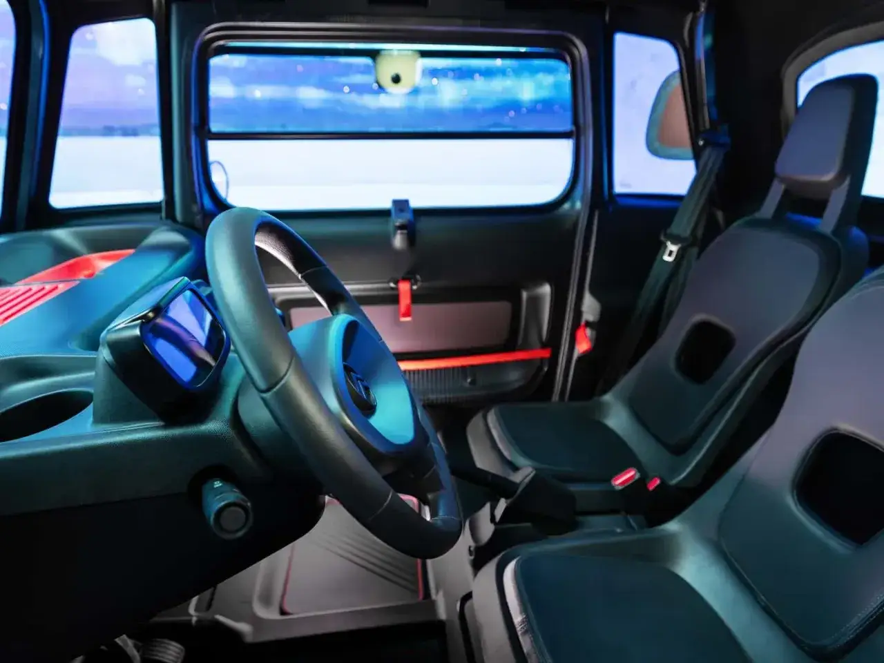 Interno della Citro&euml;n Ami, con sedili neri, volante e cruscotto. Le recensioni sulla Citro&euml;n Ami evidenziano il suo design unico.