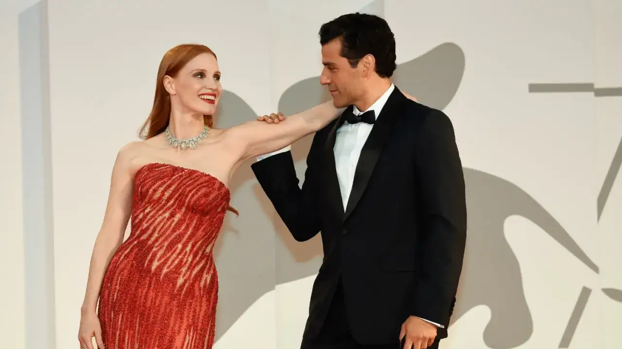 Oscar Isaac y Jessica Chastain, radiantes en la alfombra roja. Ella luce un vestido rojo brillante, &eacute;l un elegante esmoquin negro.
