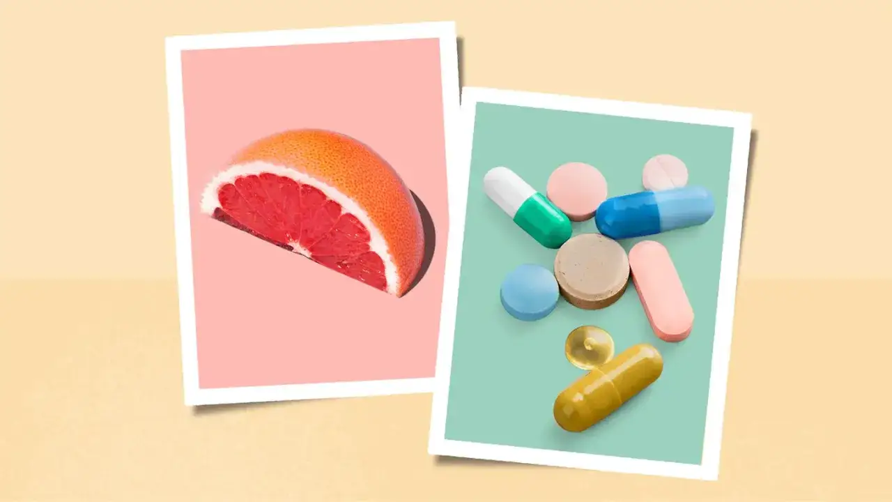 Mitad de pomelo rosado y pastillas de colores. ¿Cuáles son los beneficios del pomelo en ayunas frente a los suplementos?