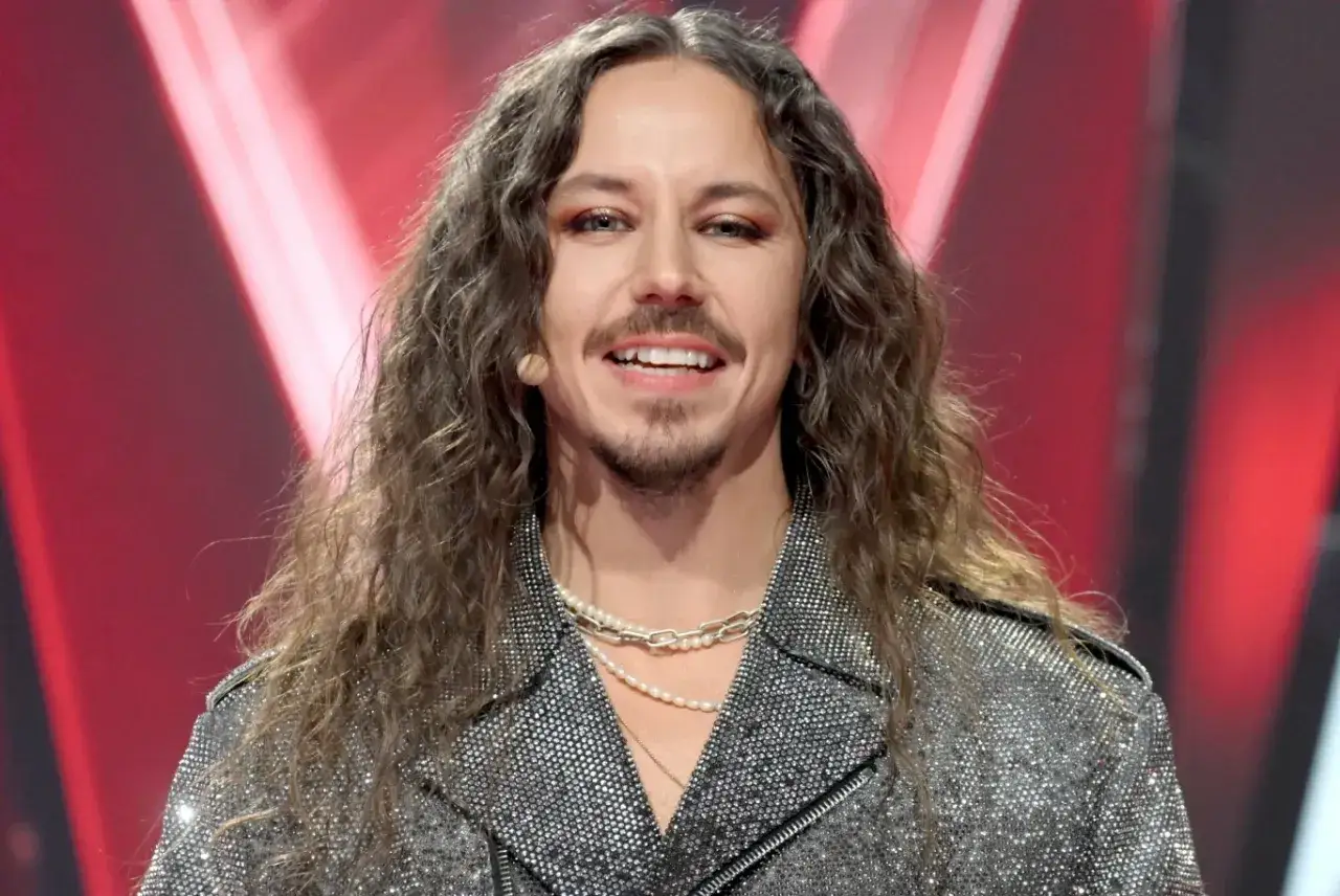 Michał Szpak, znany z charakterystycznego wizerunku, w błyszczącej kurtce i z długimi włosami. Jego wiek dodaje mu charyzmy.