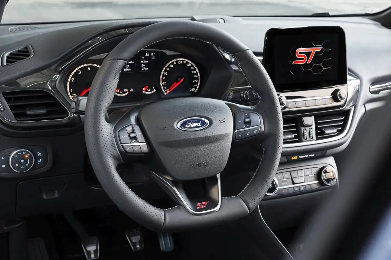 Wnętrze Ford Fiesta ST z perforowaną kierownicą, ekranem multimediów i sportowymi akcentami.