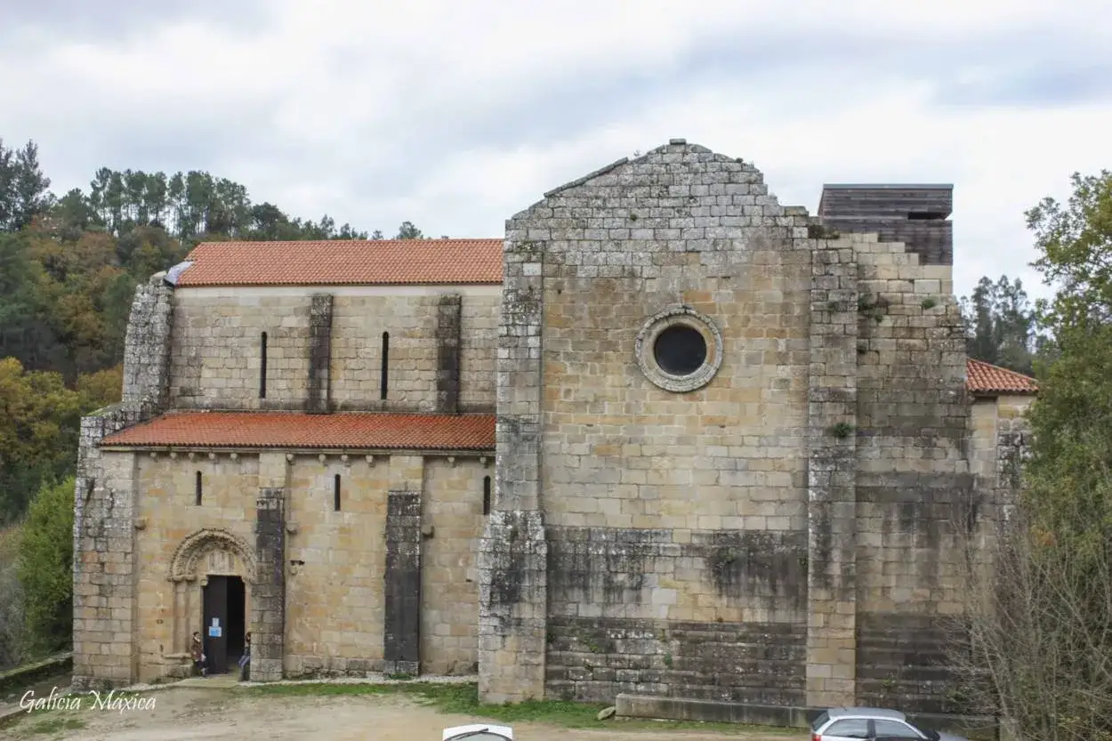 El monasterio de Carboeiro, con sus muros de piedra y tejados rojos, se alza majestuoso entre la naturaleza.