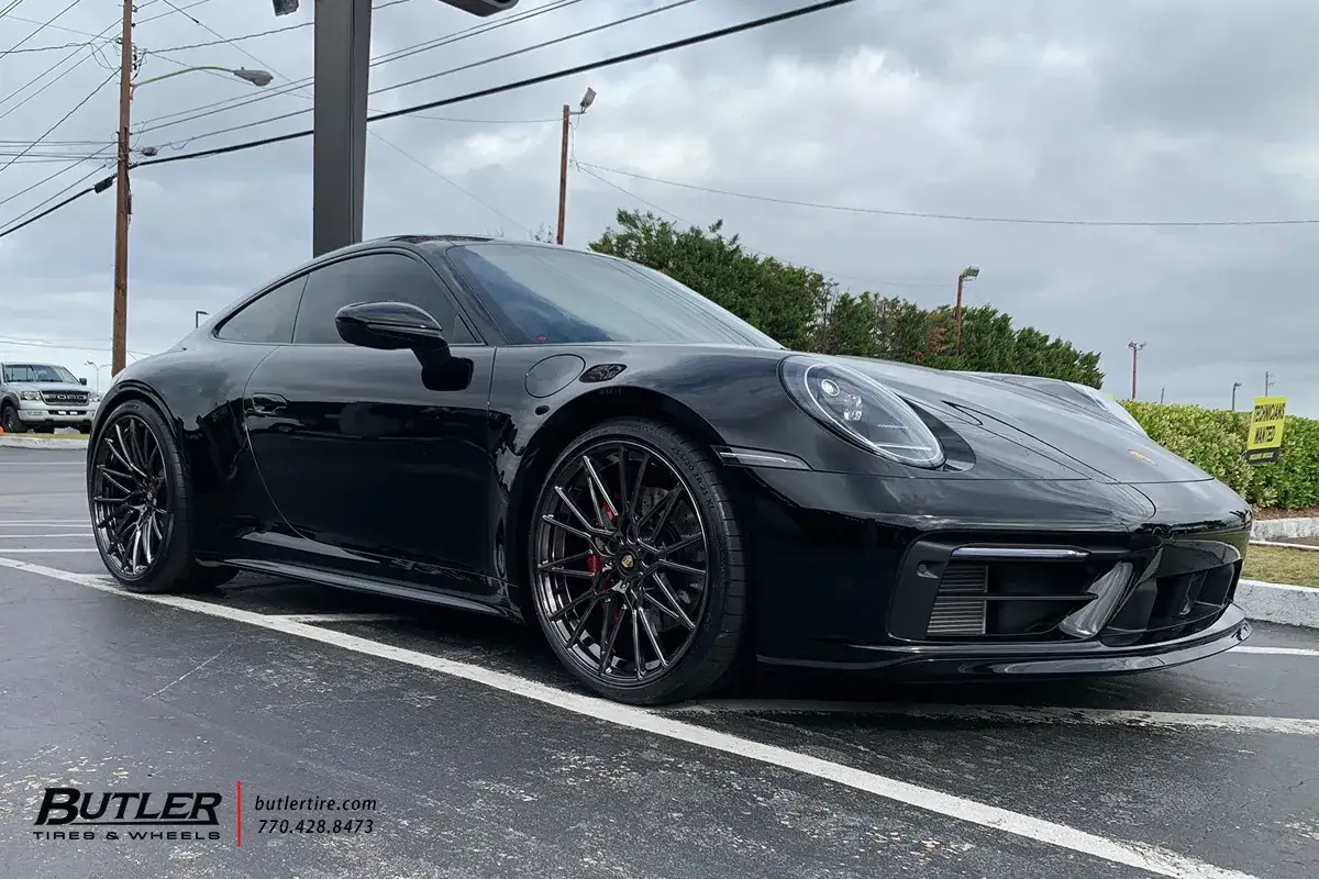 Czarny Porsche 911 Carrera 4S z przyciemnianymi szybami i błyszczącymi felgami, gotowy do jazdy.