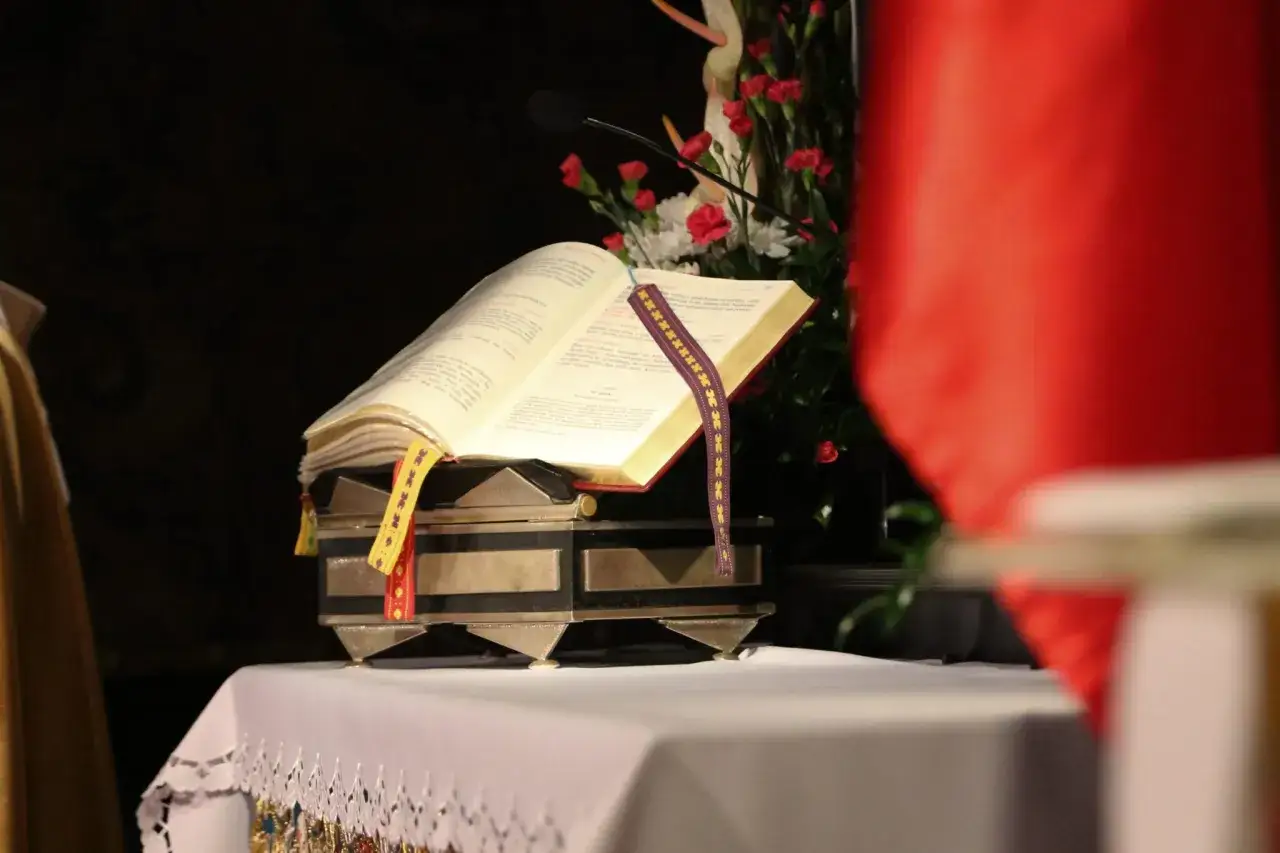 Otwarta księga na ołtarzu, z wstążkami, jak zachować się na pierwszej mszy świętej poradnik dla gości.