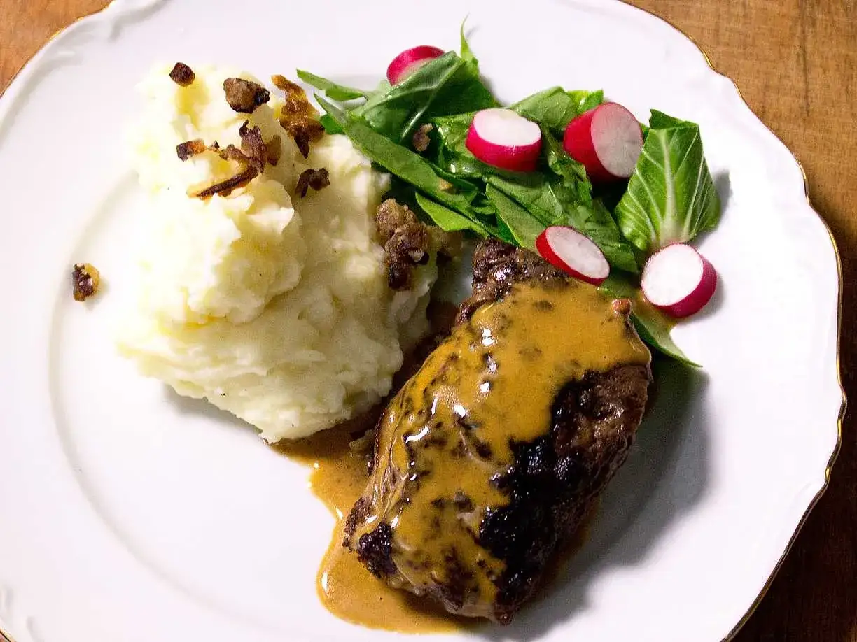 En saftig biff t&auml;ckt av kr&auml;mig bbq s&aring;s, serverad med fluffigt potatismos och en fr&auml;sch sallad med r&auml;disor.
