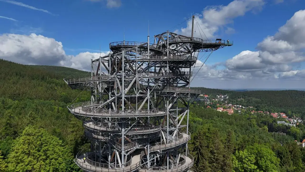 Imponująca konstrukcja sky walk wznosi się na znaczną wysokość, oferując zapierające dech w piersiach widoki na las i miasteczko.