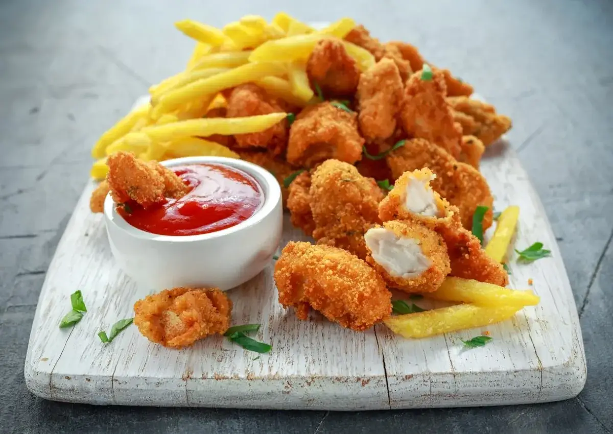 Chrupiące nuggetsy z kurczaka i frytki, idealne do dipowania w ketchupie. Pyszny przepis na nuggetsy, który pokochasz!