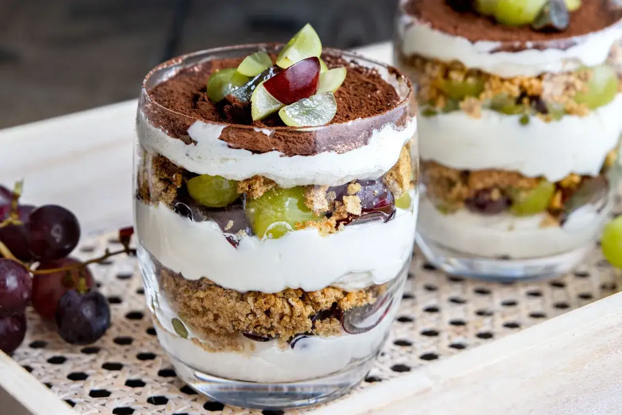 Schichtdessert im Glas mit cremigem Frischk&auml;se, zerbr&ouml;selten Keksen und saftigen Trauben. Ein k&ouml;stliches Trauben Cookie Dessert.