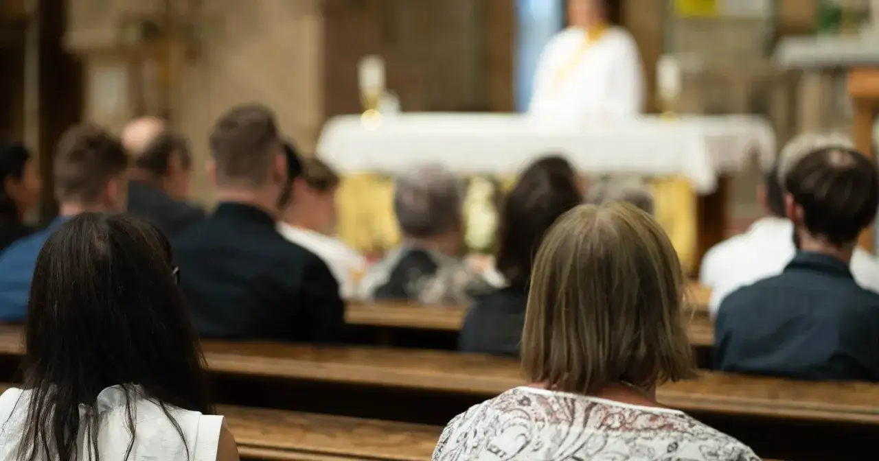 Wyniki badań socjologicznych 2026 o przyczynach utraty wiary u młodzieży. Ludzie siedzą w kościele.