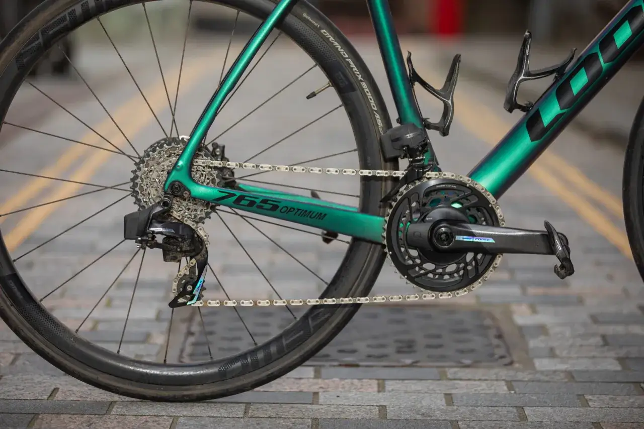 Zielony rower z napędem SRAM Force, kasetą i przerzutką. Widoczny fragment ramy z napisem 