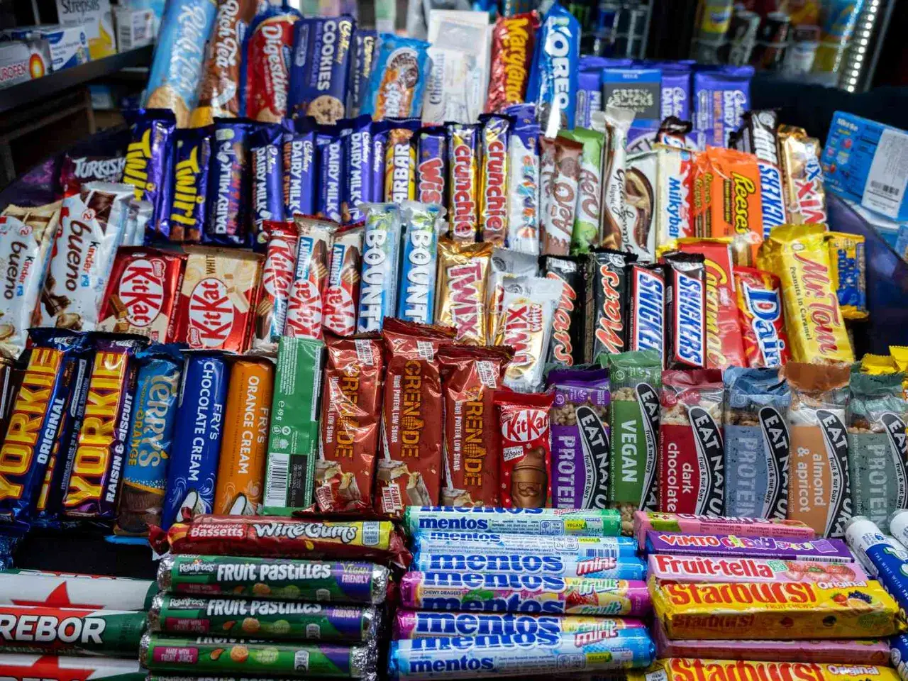 Un surtido de dulces británicos, incluyendo KitKat, Yorkie, Twix, Snickers y más, listos para ser comprados.