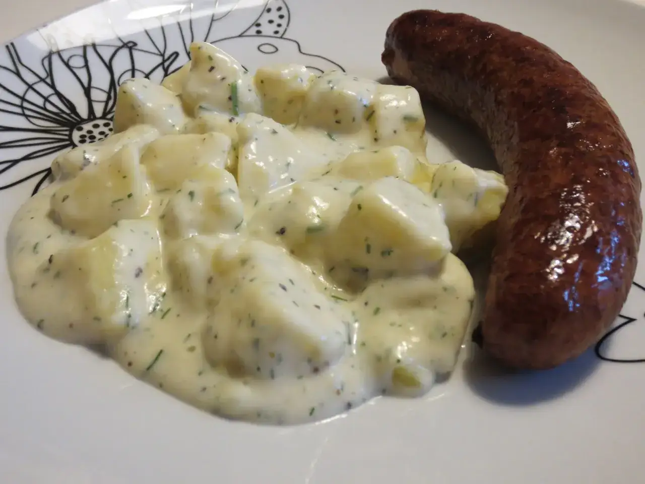 En tallrik med en stekt isterbandkorv och en kr&auml;mig potatissallad med dill. Ett klassiskt svenskt recept som passar perfekt till helgmiddagen.