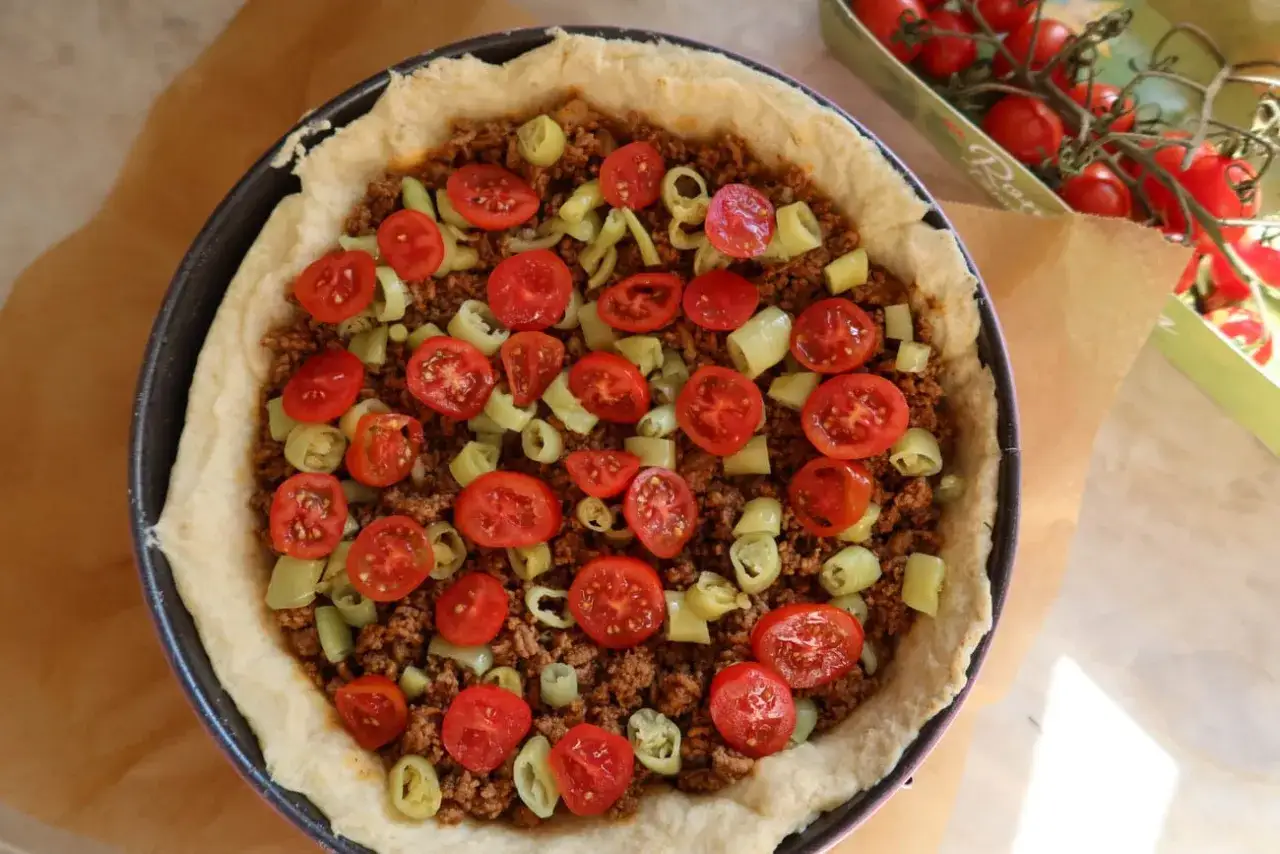 En tacopaj med k&ouml;ttf&auml;rs, k&ouml;rsb&auml;rstomater och paprika, redo f&ouml;r ugnen. Ett perfekt tacopaj recept f&ouml;r middagen.
