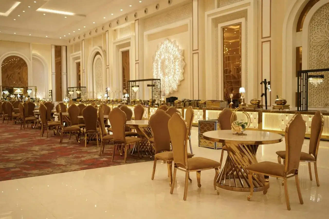 Elegancka sala bankietowa z rzędami złotych krzeseł i stołów, gotowa na wesele. Zastanawiasz się, wesele ile za osobę kosztuje w takim miejscu?