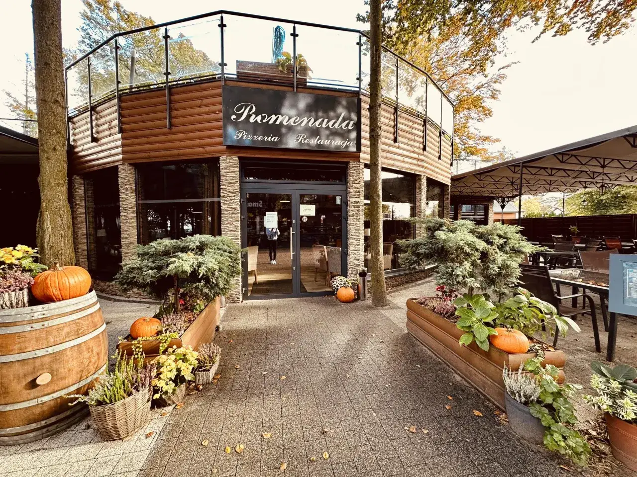 Jesienna dekoracja przed restauracją Promenada Jastrzębia Góra. Dynie i wrzosy przy wejściu.