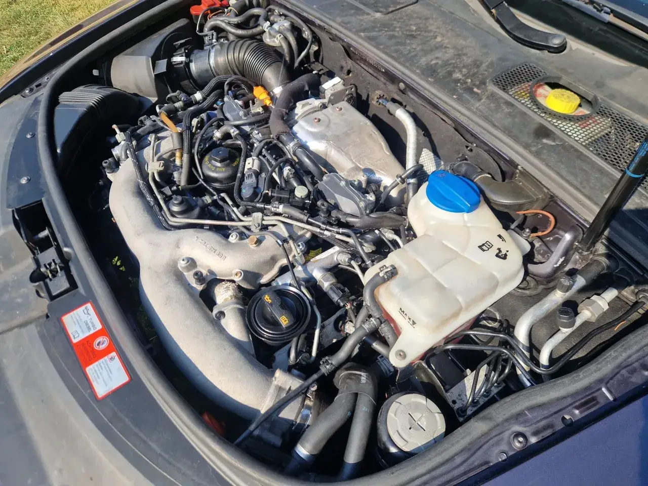Silnik Audi A6 C6 2.7 TDI z widocznym intercoolerem, przewodami i zbiorniczkiem płynu.