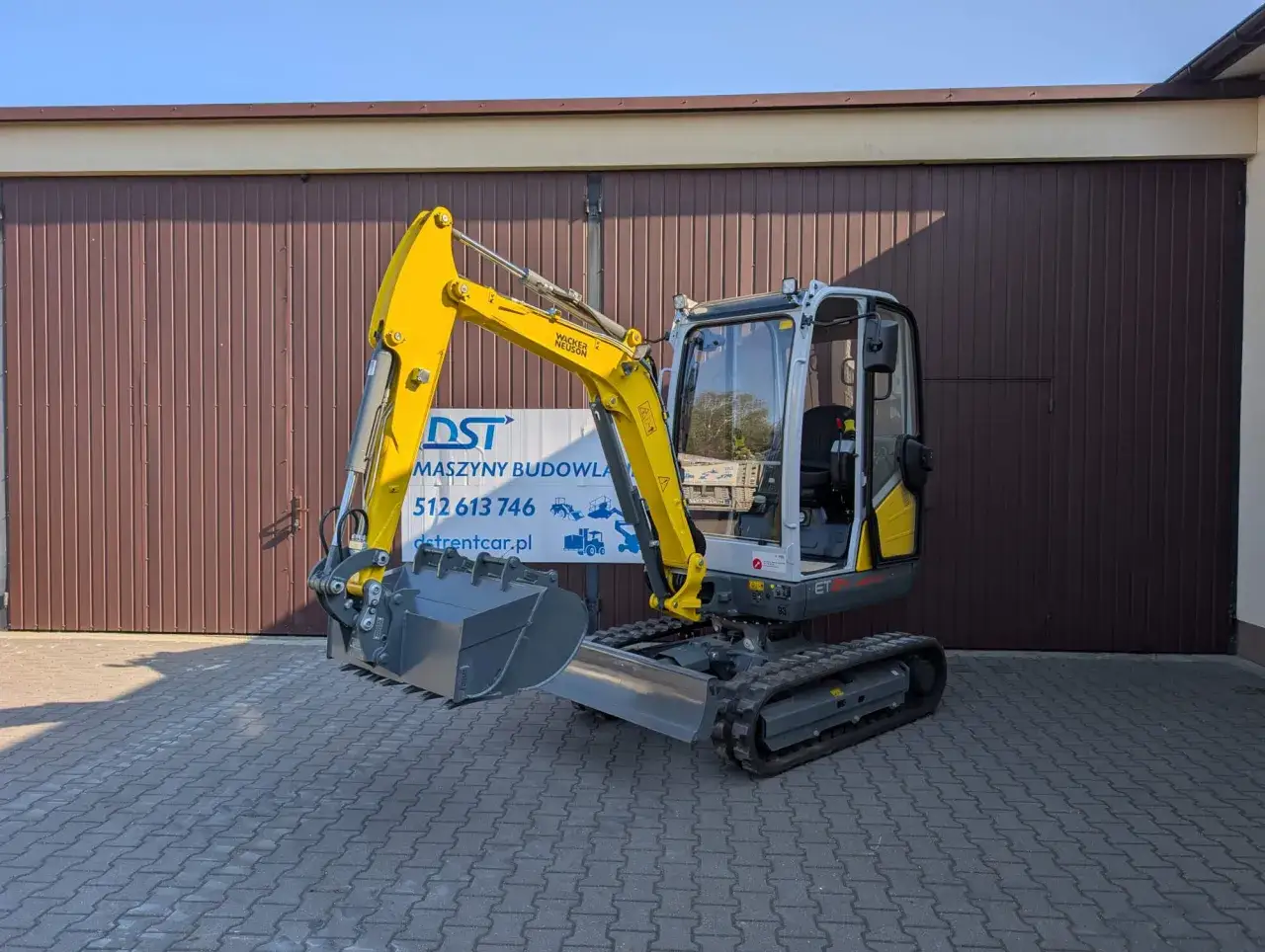 Żółta minikoparka Wacker Neuson. Dowiedz się, ile kosztuje godzina pracy minikoparki, dzwoniąc pod numer 512 613 746.