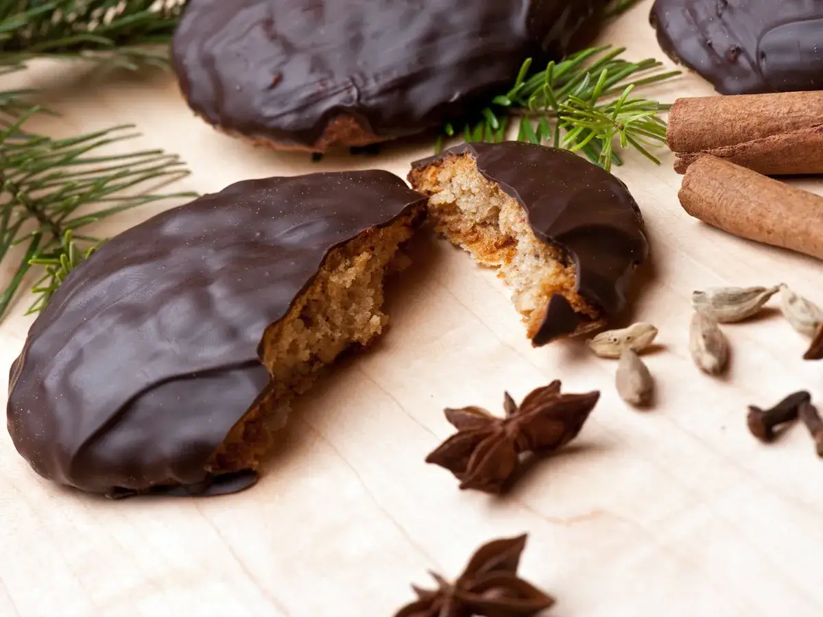 Schokoladen-Elisenlebkuchen, ein Genuss mit langer elisenlebkuchen geschichte, umgeben von Zimt, Sternanis und Kardamom.