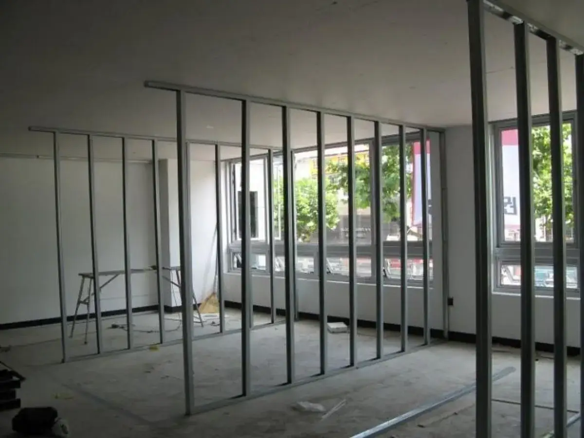 Estructura metálica para una futura pared de pladur, con ventanas al exterior y un espacio en construcción.