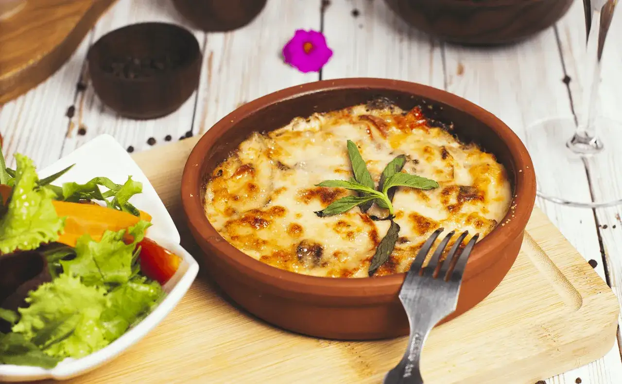 Un plat gratiné, une croute savoyarde réconfortante, servi avec une salade fraîche.