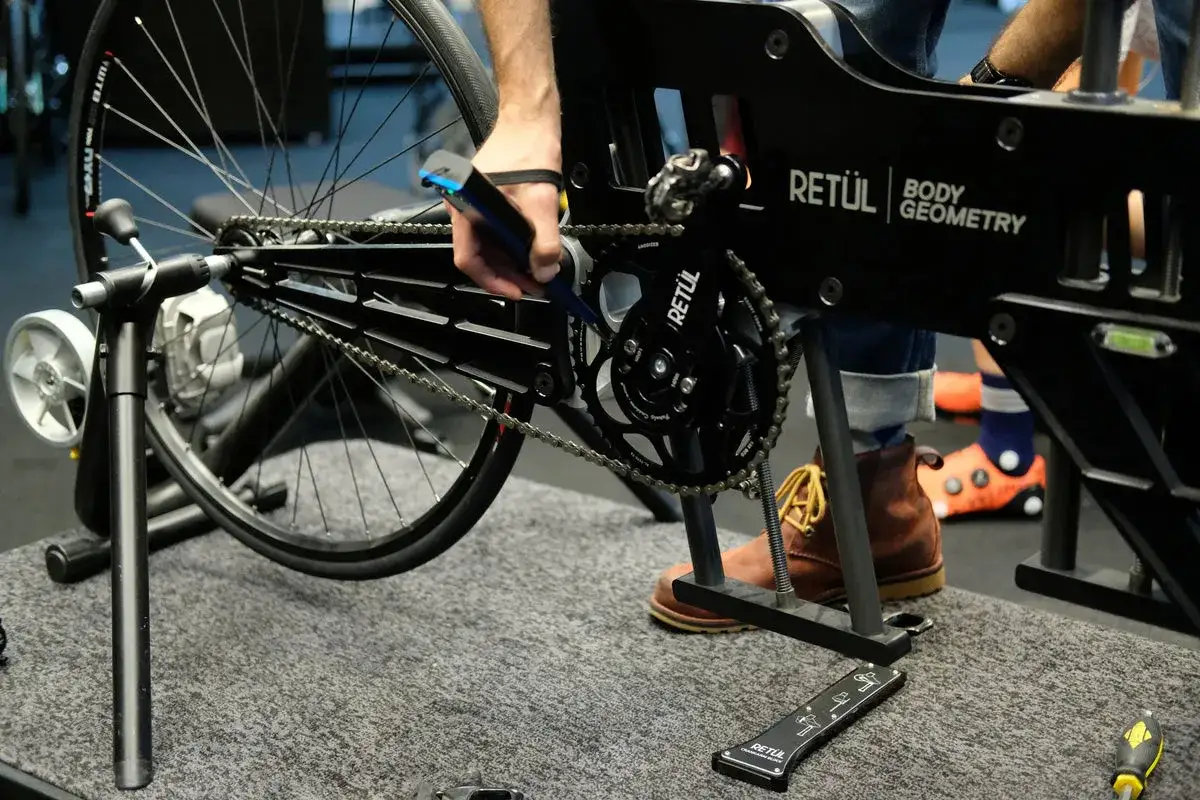 Specjalista dokonuje precyzyjnych pomiar&oacute;w podczas bike fittingu, używając narzędzi do analizy geometrii roweru.