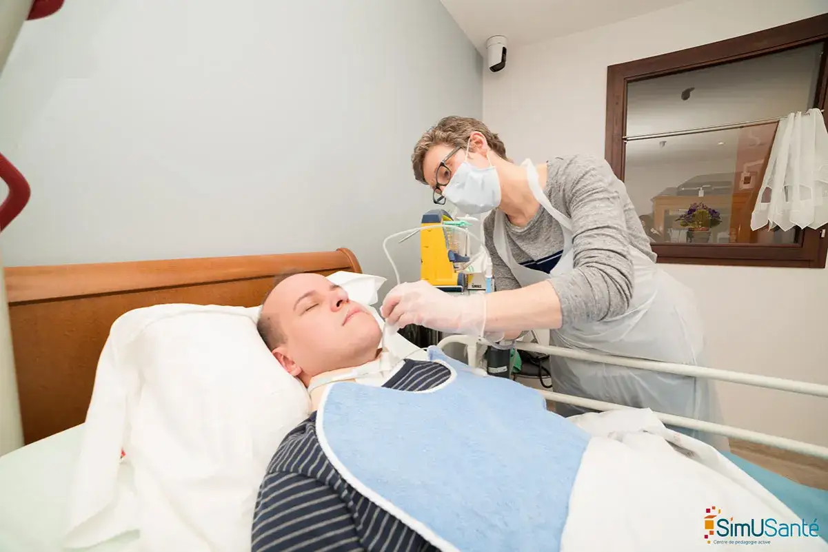 Soins à domicile pour un patient en phase terminale de cancer. Une infirmière ajuste la canule de trachéotomie.