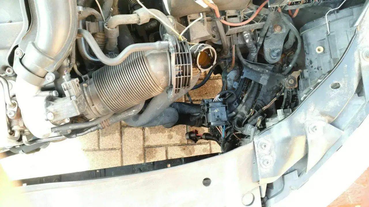 Motorraum eines VW Passat B8 mit sichtbaren Kabeln und Schläuchen. Mögliche VW Passat B8 Wasserpumpe Probleme sind hier zu sehen.