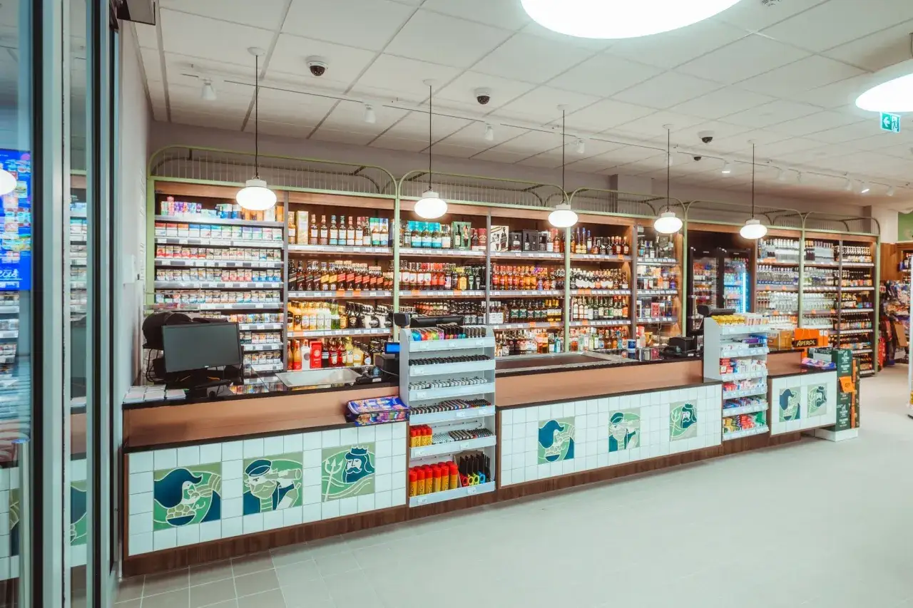 Sklep z alkoholem i papierosami, gdzie zastosowano różne techniki merchandisingu, by zachęcić do zakupu.