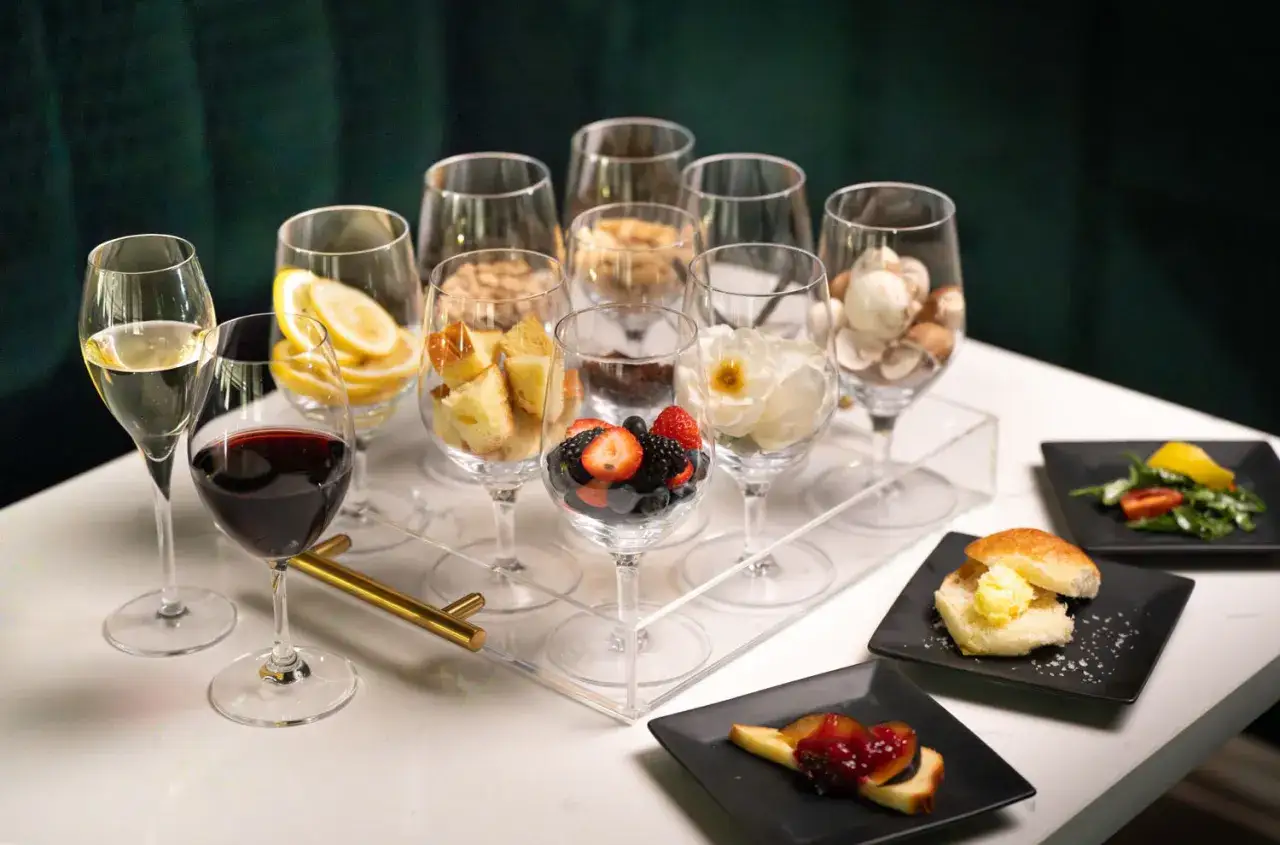 Degustacja win: kieliszek czerwonego wina, białe wino, cytryny, ciasto, jagody, kwiaty, grzyby i przekąski.